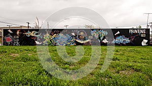 Street art decorating an outside sidewall of a printing company in Dallas, Texas on a clouldy day in spring. photo