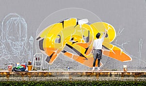 Street artist painting colored graffiti on public space wall