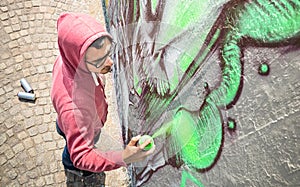 Street artist painting colorful graffiti on generic wall photo