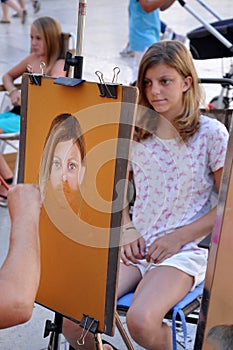 Street artist paints the portrait of a young girl. Zadar, Croatia