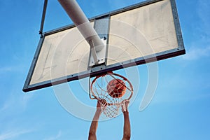 Street basketball athlete performing slam dunk on the court photo