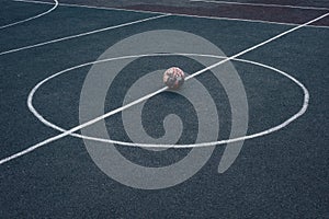 street basketball field. white stripe markings of a football field along with a soccer ball