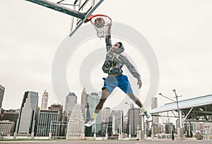 Street basketball player performing power slum dunk