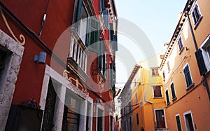 Street with beautiful old buildings of different colours in small coast city Rovinj, Croatia