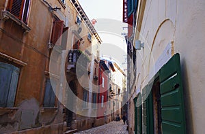 Street with beautiful old buildings of different colours in small coast city Rovinj, Croatia