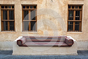 Street bench covered with ornate seat cushion in Doha