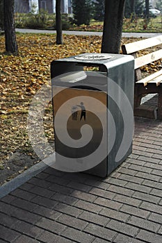 Street bench next to the modern garbage bin