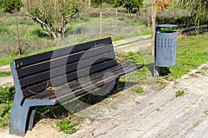 Street bench next to the modern garbage bin