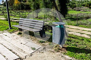 Street bench next to the modern garbage bin