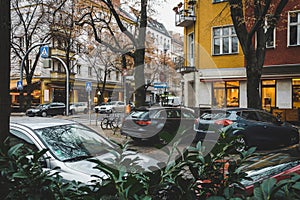 Street in Berlin in autumn with cafes, shops, restaurants and cars.. Travel and tourism in Berlin concept