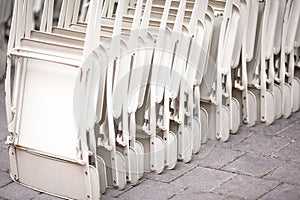 Street cafe chairs. Empty assembled white chairs on the terrace of a restaurant outside