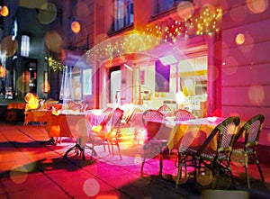 Street cafe at night city cup of coffee on table pink blue blurring light  Tallinn