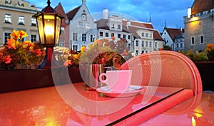 Street cafe  restaurant table cup of coffee on top view candle lamp  light reflection on glass  summer night in the city  holiday