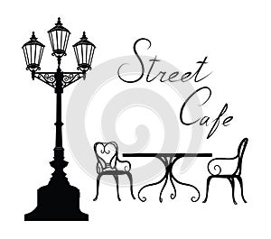 Street cafe - table, chairs, streetlight and lettering City life photo