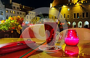 Street cafe table with glass of tea candle light flowers city lamp light red yelloew green colored  town of Tallinn ,Estonia 20,