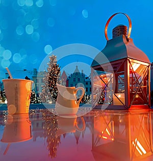 Street cafe Winter Tallinn old town  Christmas tree on  hall square  street cafe table with cup of coffee milk and lantern  blurre