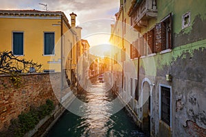 Street canal in Venice, Italy. Narrow canal among old colorful brick houses in Venice, Italy. Venice postcard