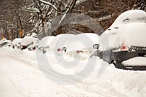 The street and cars are full of snow after a big snowstorm during winter season in Montreal, Quebec.