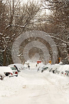 The street and cars are full of snow after a big snowstorm during winter season in Montreal, Quebec.