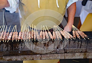 street chef cooks the raw red meat grilled