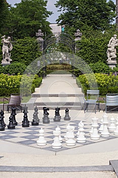 Street chessboard with black and white chessmen in the summer day in park