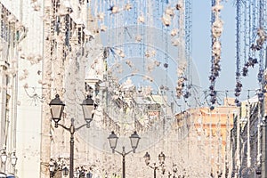 Street christmas decoration. White garlands above the street