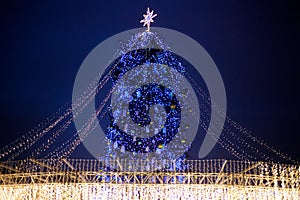 Street city Christmas tree at night. The garlands are burning. Holiday decorations and toys. Garland of lights.