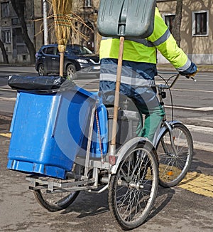 Street cleaner man on bicycle with garbage can