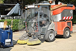 Street cleaner vehicle and garbage can on the road