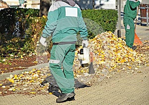 Street cleaners work in autumn