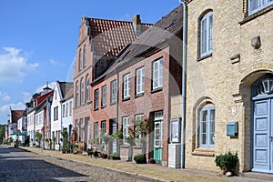 Street with cobblestone pavement and roses  in Friedrichstadt, the beautiful town and travel destination in northern Germany photo