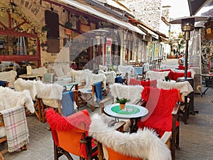 Street coffee shop tables and chairs with warm cloth in Kalari street Ioannina city