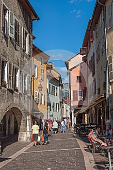 Street with colorful old buildings and pedestrians in Annecy.