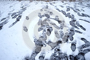 Street covered with snow and imprints of the shoes of the passers by