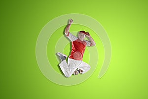 Street dancer jumping isolated over green background