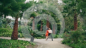 Street dancers dancing latino style in tropical park. Performers enjoy dance.