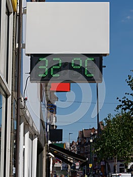 Street digital thermometer displaying a temperature of 32 degrees celsius. Heat wave concept.