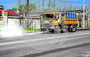 Street disinfection - a sweeper washes the city`s asphalt road with water jets.