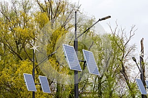 Street electricity by a small windmill and solapanels in city against buildings in daytime. Concept of newable, eco or