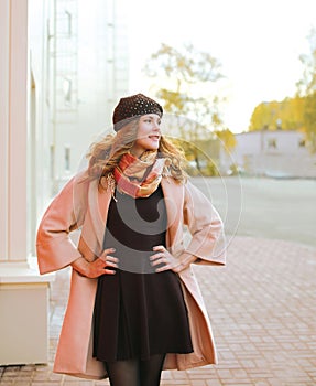 Street fashion, beautiful woman in coat posing in the city