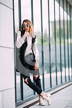 Street fashion concept - pretty young slim woman in rock black style posing against the wall