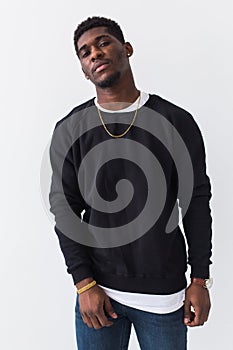 Street fashion concept - Studio shot of young handsome African man wearing sweatshirt against white background.