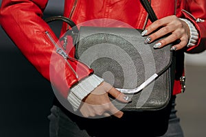 Street fashion concept. Woman in trendy apparel holding black le