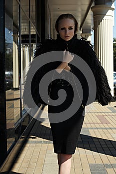 Street fashion style. Beautiful model in chic warm jacket with fluffy fur