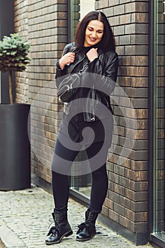 Street fashion style concept. Fashion hipster woman posing outdoor. Sensual cute girl wearing black leather jacket. Women fashion