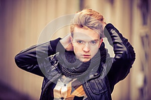 Street fashion. Young fashionable man guy with stylish haircut clothes posing outdoor on cityspace background. Aged tone.