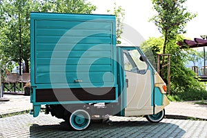 Street fast food coffee shop truck mockup for business logo, retro italian Piaggio Ape three-wheeled commercial scooter on the