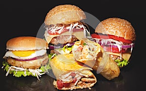 Street fast  food concept on a dark bakground,burgers with meat and vegetables, shawarma with chicken