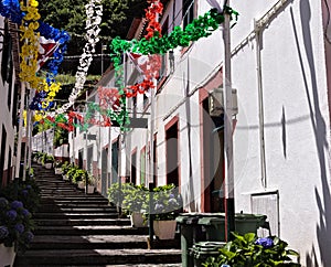 A street with a flight of steps decorated with colored paper flowers for a traditional festival in Sao Vicente Madeira, Portugal