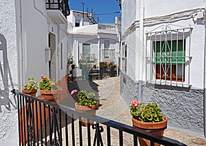 Street with flower pots in facades. Village in the Alpujarra